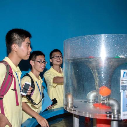 Students were visiting the science museum in Macau and were observing the exhibits.