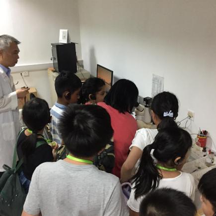 學生正參訪廣東出入境檢驗檢疫局，聆聽工作人員介紹檢驗程序。