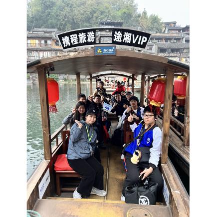 学生于凤凰古城乘船游览沱江。