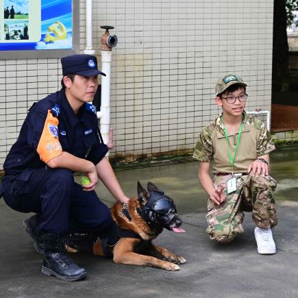 學員參觀警犬訓練基地，與訓練人員和警犬合影。