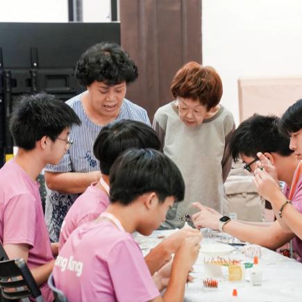 學生正專心跟從非遺小火龍工作坊導師的指導，製作自己的作品。