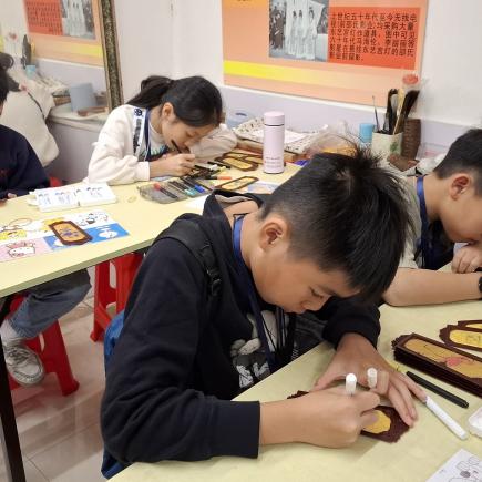 學生用心地在燈片上繪製喜歡的圖案，準備製作宮燈。